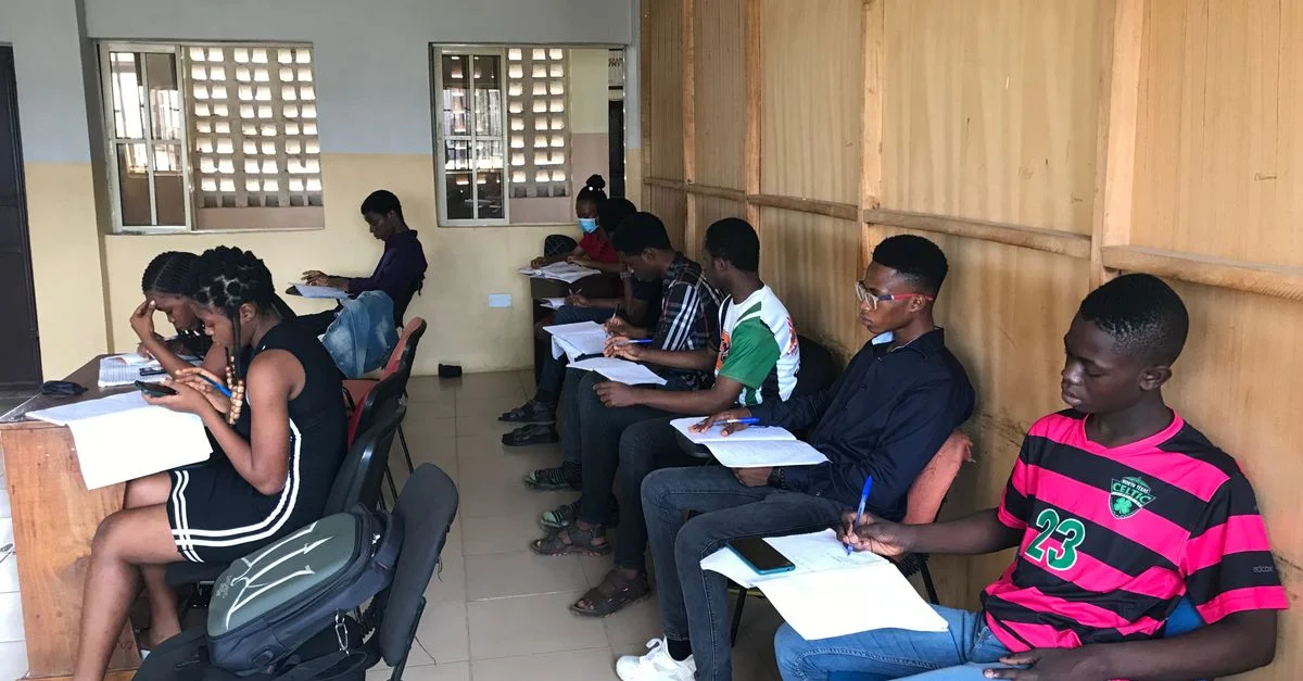 Un groupe diversifié d'adolescents se concentrant sur leurs études dans un environnement de classe, assis en rang.